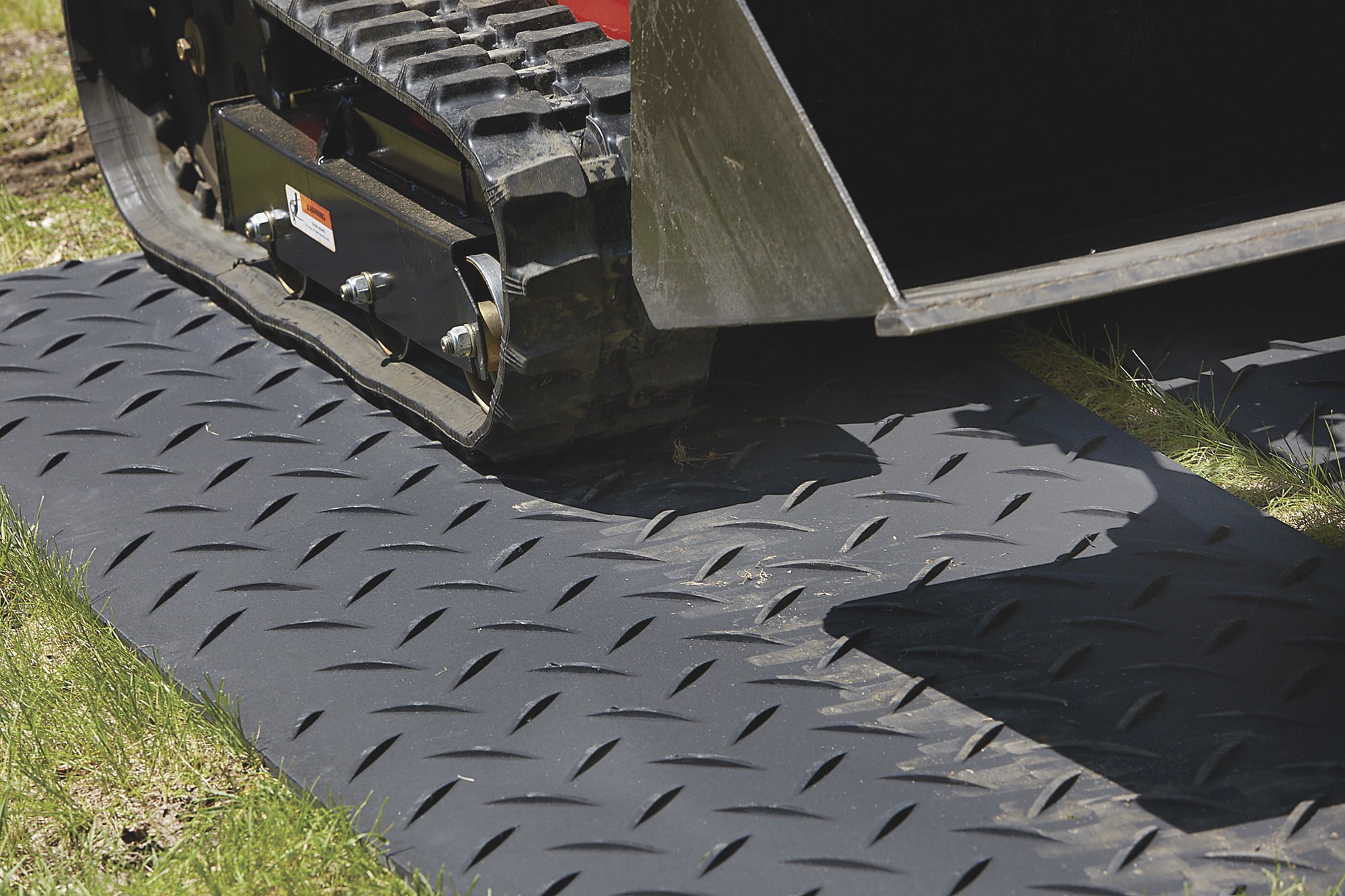 Skid steer on ground protection mats
